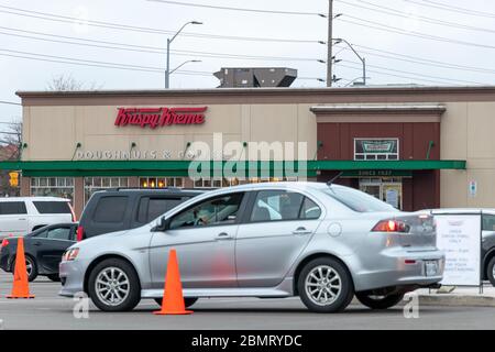 Krispy Kreme Doughnuts & Coffee shop with cars in a outfront in a big line-up waiting to pick-up amid the global COVID-19 pandemic. Stock Photo