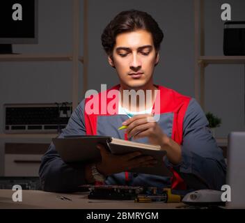 The young handsome repairman repairing computer Stock Photo