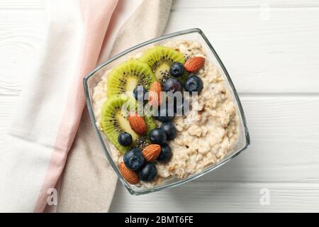 Towel and bowl with oatmeal porridge and fruits on wooden background Stock Photo