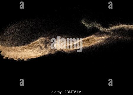 Brown sand explosion isolated on black background. Freeze motion of sandy dust splash.Sand texture concept. Stock Photo