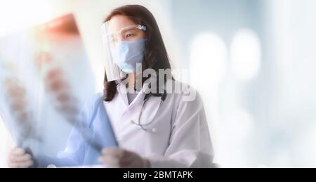 asian female doctor looking at the x-ray picture of lungs in hospital Stock Photo