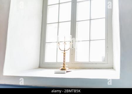 Candlestick for three candles in a chirch window.. Stock Photo