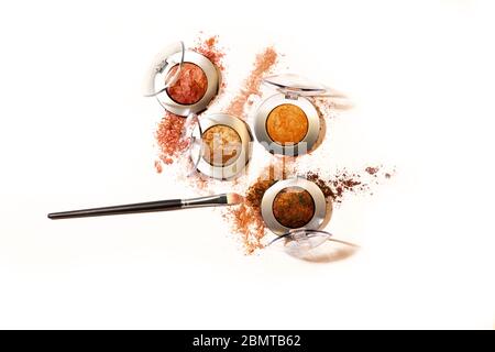 Shimmery and glittery eye shadow compacts isolated on white background with applying brush Stock Photo