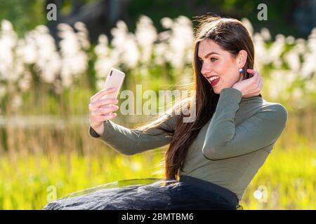 young beautiful emotional brunette woman is surprised with the message she received on the phone, love message Stock Photo