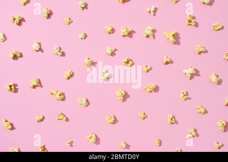 Food pattern from delicious popcorn on a light pink background. Stock Photo