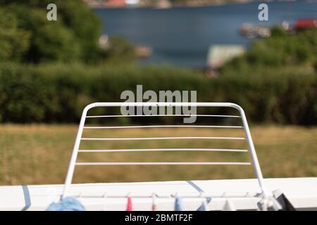 drying rack in sunlight. A garden in the background.. Stock Photo