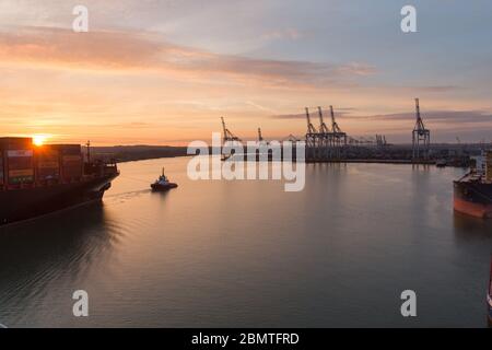 City of Southampton, England. Picturesque sunset view of a container ship navigating the River Test at Southampton Docks. Stock Photo