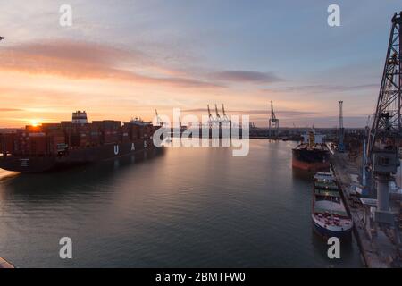 City of Southampton, England. Picturesque sunset view of a container ship navigating the River Test at Southampton Docks. Stock Photo