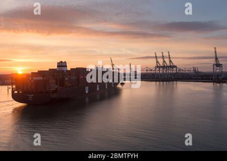 City of Southampton, England. Picturesque sunset view of a container ship navigating the River Test at Southampton Docks. Stock Photo