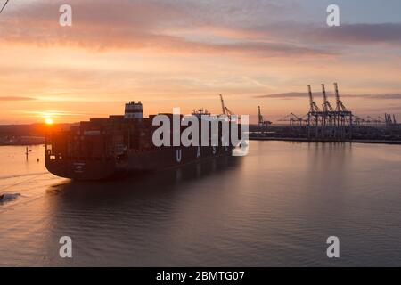 City of Southampton, England. Picturesque sunset view of a container ship navigating the River Test at Southampton Docks. Stock Photo