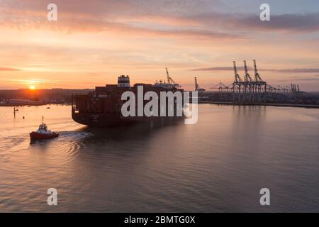 City of Southampton, England. Picturesque sunset view of a container ship navigating the River Test at Southampton Docks. Stock Photo