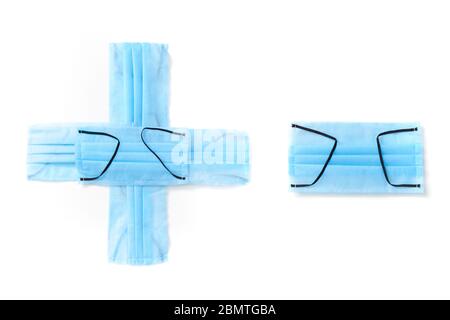 Sign plus and minus made from protective medical masks on a white background. Stock Photo