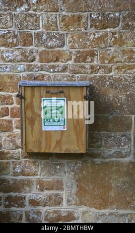 Defibrillators housed in a wooden case attached to the wall of the village hall in the north Oxfordshire village of Swerford Stock Photo