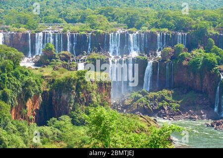 Iguazu waterfalls in Argentina, view from Devil's Mouth. Panoramic view of many majestic powerful water cascades with mist and splashes. Panoramic ima Stock Photo
