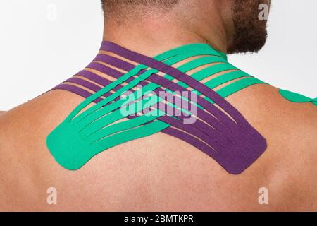 Kinesiology taping.Close up view of kinesiology tape on patient neck.Young male athlete on white background.Post traumatic rehabilitation,sport Stock Photo