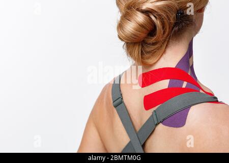Kinesiology taping.Close up view of kinesiology tape on patient neck.Young female athlete on white background.Post traumatic rehabilitation,sport Stock Photo