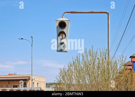 Vintage old traffic light on a rusty post. Close-up. Stock Photo