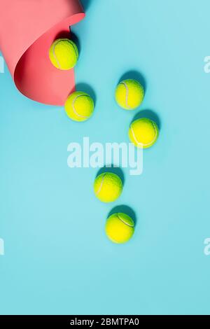 Sport concept with tennis balls close up on blue tennis court. Copy space, selective focus. Blue, pink and yellow.