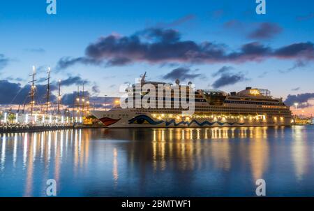 Las Palmas, Gran Canaria, Canary Islands, Spain. 11th, May 2020. The sun rises behind quarantined cruise ship and luxury three masted cruise ships in Las Palmas port on Gran Canaria as the Canary Islands, and other regions of Spain, enters phase 1 of a four phase gradual easing of lockdown restrictions. Permitted during Phase 1 (with emphasis on social distancing) includes; opening of hotels, churches, libraries, cafes, smaller shops, groups of up to 10 people, visiting family and second homes... Some of the Coronavirus hotspots, like Madrid, will remain at phase 0 until deemed safe to move to Stock Photo