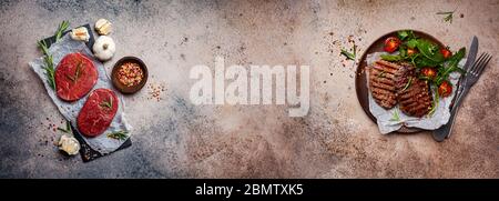 Meat banner background. Raw beef meat on a slate board with spices and grilled beef steaks with salad on a plate. Dark background, top view, copy spac Stock Photo