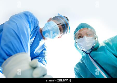 Giving first medical help in hospital. Doctors give resuscitation to patient in the emergency room Stock Photo