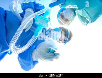 Giving first medical help in hospital. Doctors give resuscitation to patient in the emergency room Stock Photo