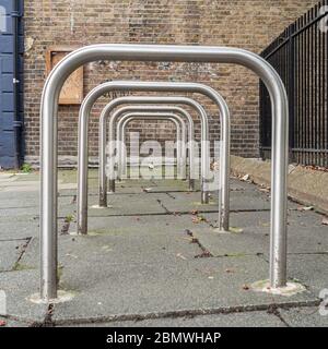 Row of empty Sheffield stand bike racks on the pavement Stock Photo