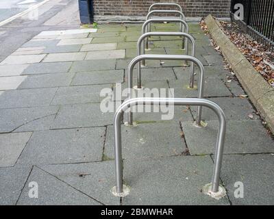 Row of empty Sheffield stand bike racks on the pavement Stock Photo