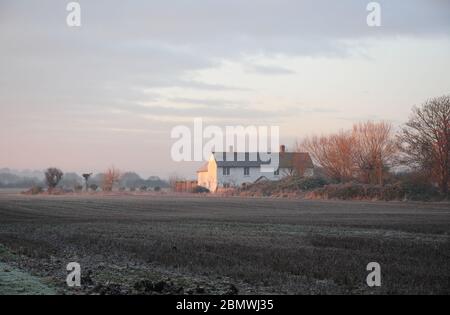 Frosty sunrise, early December. Farmhouse and stubble field, Coastal Plain, West Sussex. Stock Photo