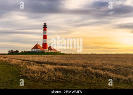 Lighthouse Westerhever near Sankt(St.) Peter Ording at sunset with beautiful stunning sky and dramatic clouds Stock Photo