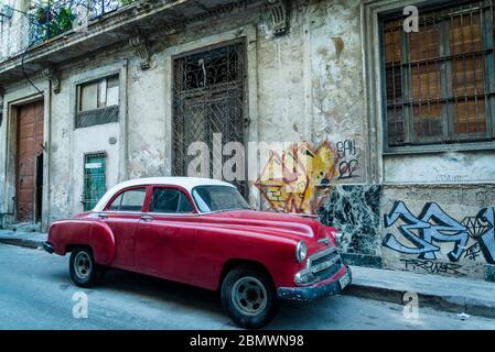 Vintage car driving through an Atmospheric street with cobblestones in the Old City Centre, Havana Vieja, Havana, Cuba