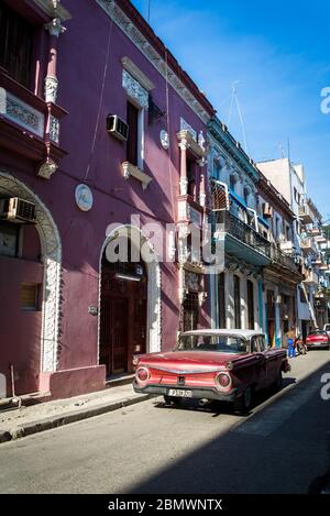 Vintage car driving through Typical narrow street in the Old City Centre, Havana Vieja, Havana, Cuba Stock Photo