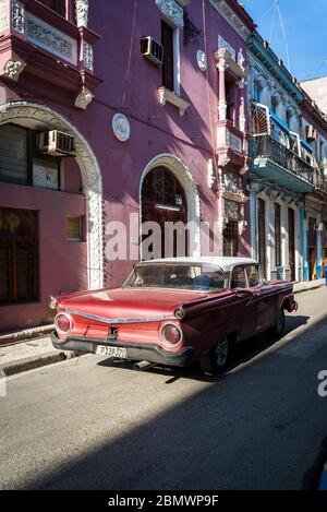 Vintage car driving through Typical narrow street in the Old City Centre, Havana Vieja, Havana, Cuba Stock Photo
