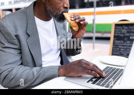 African American man working on his laptop at coffee terrace Stock Photo