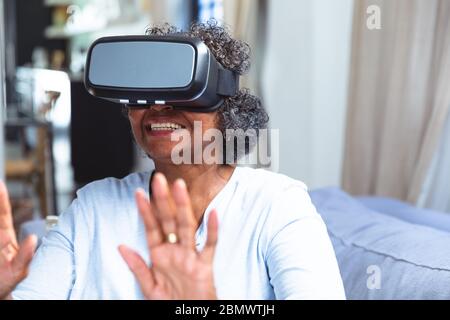 Senior African American woman using VR at home during quarantine lock down for coronavirus covid19 Stock Photo