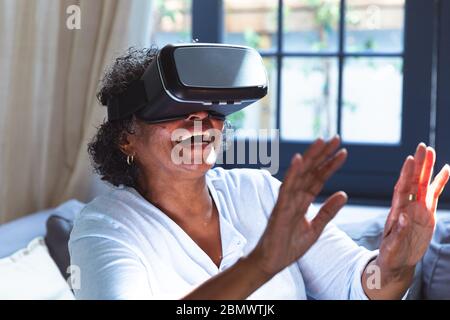 Senior African American woman using VR at home during quarantine lock down for coronavirus covid19 Stock Photo