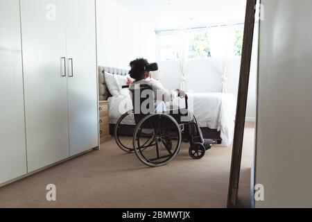 Senior African American woman on wheelchair using VR at home during quarantine lock down for coronav Stock Photo