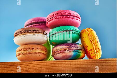Multi-colored Macaron folded in a stack on a wooden background. Shooting from below Stock Photo