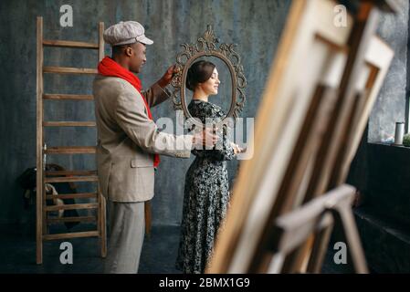 Portrait painter holds frame, female model Stock Photo