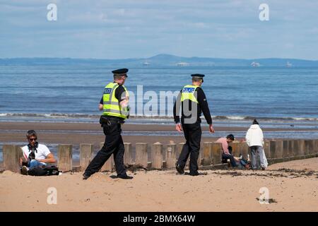 Portobello, Scotland, UK. 11 May 2020. Police patrolling promenade and beach at Portobello this afternoon in warm sunny weather. They spoke to the public who were sitting on the beach or on sea wall asking them to keep moving. Iain Masterton/Alamy Live News Stock Photo