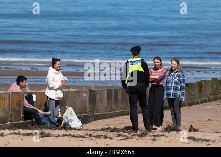 Portobello, Scotland, UK. 11 May 2020. Police patrolling promenade and beach at Portobello this afternoon in warm sunny weather. They spoke to the public who were sitting on the beach or on sea wall asking them to keep moving. Iain Masterton/Alamy Live News Stock Photo