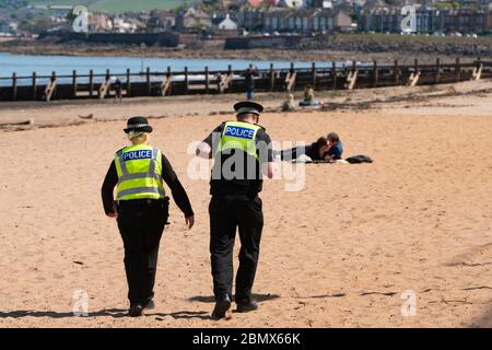 Portobello, Scotland, UK. 11 May 2020. Police patrolling promenade and beach at Portobello this afternoon in warm sunny weather. They spoke to the public who were sitting on the beach or on sea wall asking them to keep moving. Iain Masterton/Alamy Live News Stock Photo