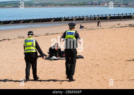 Portobello, Scotland, UK. 11 May 2020. Police patrolling promenade and beach at Portobello this afternoon in warm sunny weather. They spoke to the public who were sitting on the beach or on sea wall asking them to keep moving. Iain Masterton/Alamy Live News Stock Photo