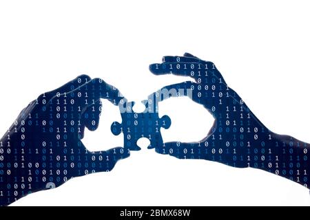 Silhouette of a hands holding a jigsaw puzzle piece with binary background Stock Photo