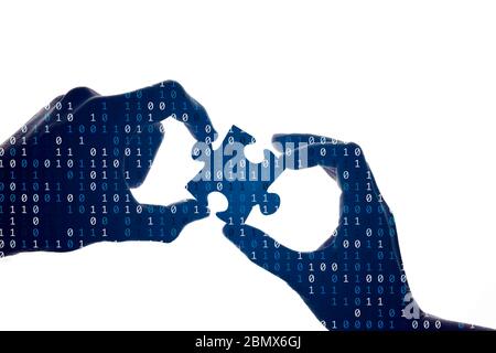 Silhouette of a hands holding a jigsaw puzzle piece with binary background Stock Photo