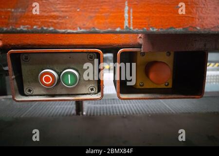 Metal box with Start and Stop buttons and an emergency switch on the conveyor factory line Stock Photo