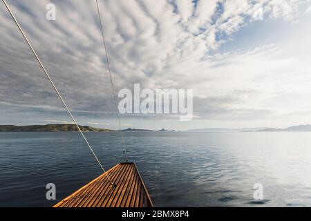 Sunset idyllic ocean view from wooden boat. Sea background. Cruise or yacht trip. Stock Photo