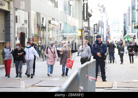 Brussels, Belgium. 11th May, 2020. A policeman stands to keep the traffic in order at the main shopping street, the Avenue Nouvelle, in Brussels, Belgium, May 11, 2020. Belgium entered phase 1B of the COVID-19 deconfinement on Monday, with businesses throughout the country allowed to reopen under strict conditions. Credit: Zheng Huansong/Xinhua/Alamy Live News Stock Photo