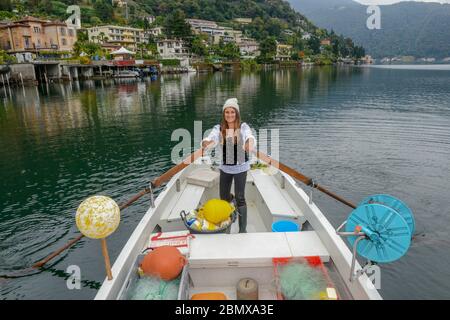 Lugano, Switzerland - 18 Oktober 2016: woman in her fishing boat on lake Lugano on Switzerland Stock Photo