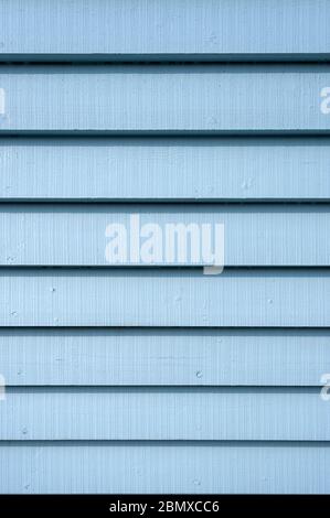 Blue painted wooden clapboard planks on the side of a building , close up. Stock Photo